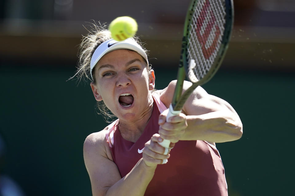 Simona Halep, of Romania, returns a shot against Sorana Cirstea, of Romania, at the BNP Paribas Open tennis tournament Tuesday, March 15, 2022, in Indian Wells, Calif. (AP Photo/Marcio Jose Sanchez)