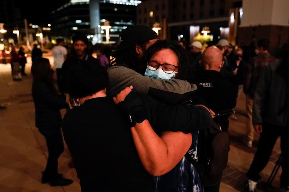 Three film industry workers comfort one another during a candlelight vigil held to honor cinematographer Halyna Hutchins in Albuquerque, N.M., Saturday, Oct. 23.