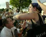 FILE - In this Saturday, July 14, 2001 file photo, abortion-rights activist Karen Nicholls of Chicago, right, shields herself from anti-abortion leader Rev. Flip Benham, left, as Benham attempts to pray for Nicholls during a protest by the two groups , at a Wichita, Kan., abortion clinic. (AP Photo/Charlie Riedel, file)