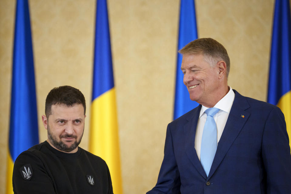 Ukraine's President Volodymyr Zelenskyy, left, shakes hands with Romanian President Klaus Iohannis, right, at the end of joint press statements at the Cotroceni Presidential Palace in Bucharest, Romania, Tuesday, Oct. 10, 2023. (AP Photo/Andreea Alexandru)