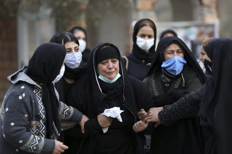 Relatives of Keyumars Ziaee, 60, who died from COVID-19 mourn at a cemetery in the Shir Kola village on the outskirts of the city of Ghaemshahr, in northern Iran, Wednesday, Dec. 16, 2020. (AP Photo/Ebrahim Noroozi)