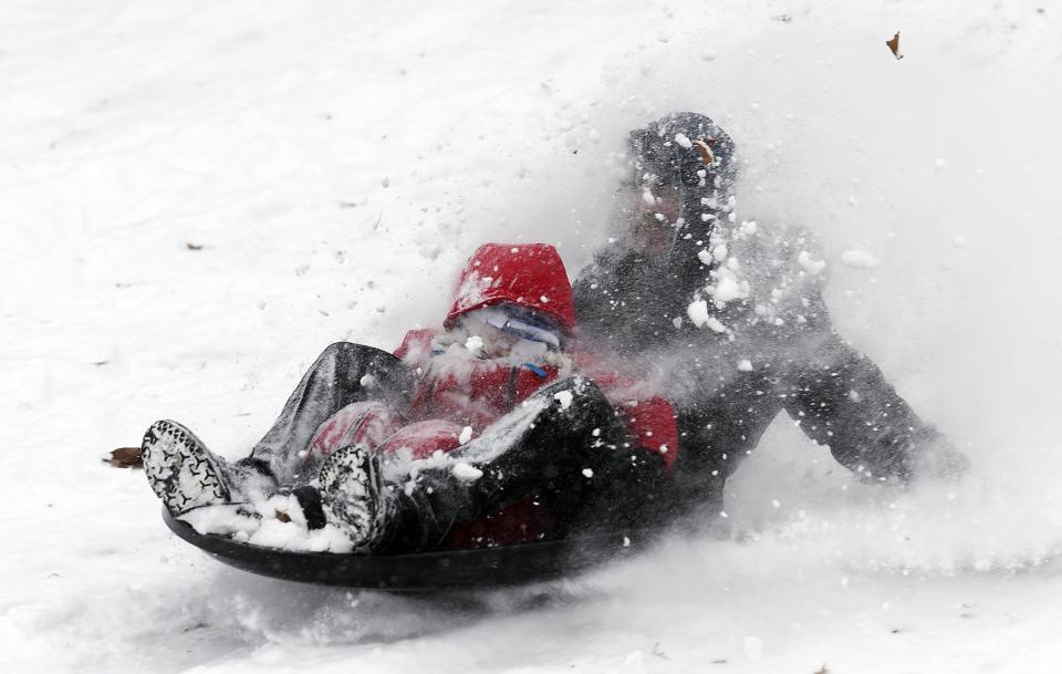 A father and son toboggan during a snow storm in Toronto