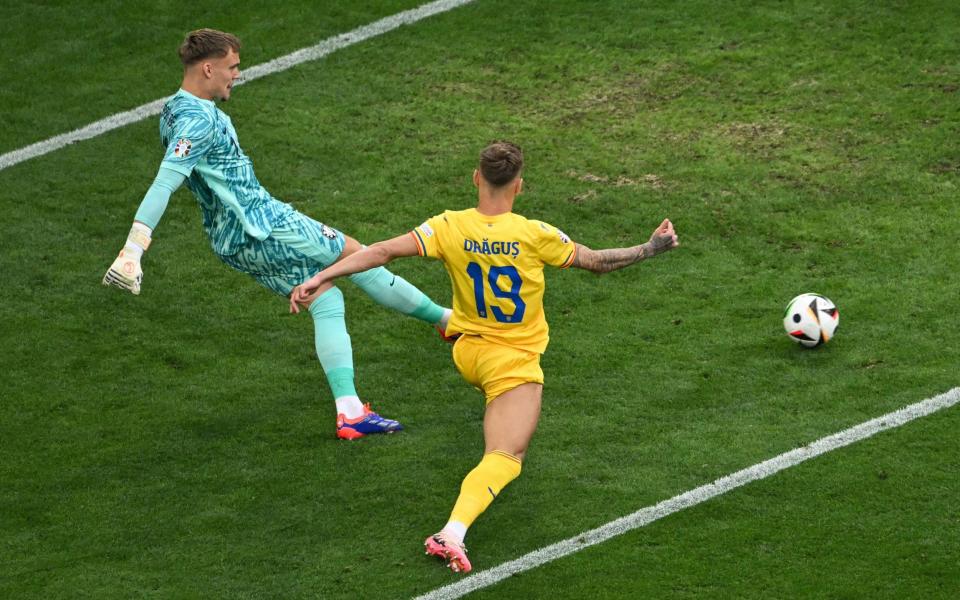 Bart Verbruggen clears the ball ahead of Romania's forward #19 Denis Dragus during the UEFA Euro 2024 round of 16 football match between Romania and the Netherlands at the Munich Football Arena in Munich on July 2, 2024.