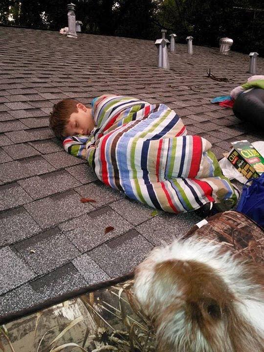 Un niño duerme en un tejado, atrapado entre la riada junto a su mascota, mientras esperaba a ser rescatado (Facebook)