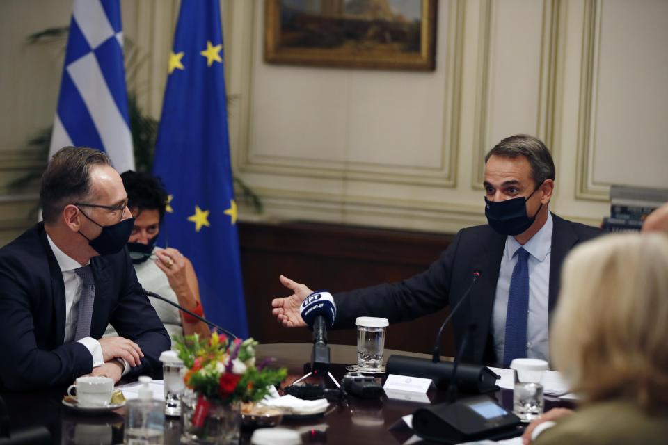 Greece's Prime Minister Kyriakos Mitsotakis, right, speaks with Germany's foreign minister Heiko Maas during their meeting at Maximos Mansion in Athens, Tuesday, Oct. 13, 2020. Maas on Tuesday criticized Turkey for "unilateral steps" in the eastern Mediterranean that are undercutting efforts to de-escalate tensions with Greece and Cyprus over sea boundaries and drilling rights. (AP Photo/Thanassis Stavrakis)