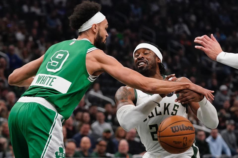 Boston Celtics' Derrick White knocks the ball from Milwaukee Bucks' Jrue Holiday during the first half of an NBA basketball game Thursday, April 7, 2022, in Milwaukee. (AP Photo/Morry Gash)