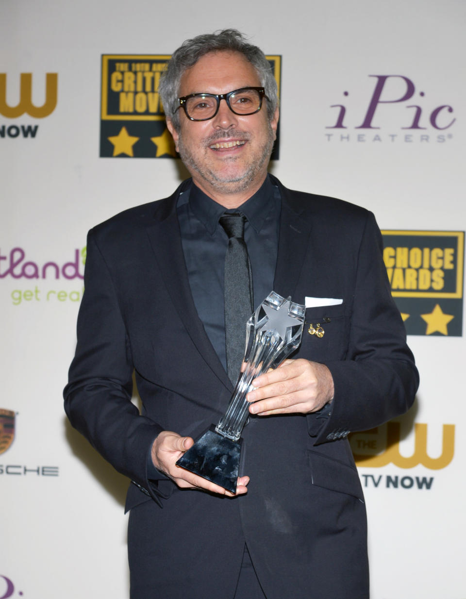 Alfonso Cuaron poses with the award for best director for "Gravity" in the press room at the 19th annual Critics' Choice Movie Awards at the Barker Hangar on Thursday, Jan. 16, 2014, in Santa Monica, Calif. (Photo by John Shearer/Invision/AP)