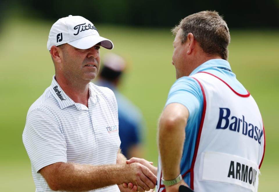 Former Walsh Jesuit and Ohio State player Ryan Armour (left) reacts to his birdie putt with his caddie of the 18th green Thursday at the PGA Barbasol Championship.