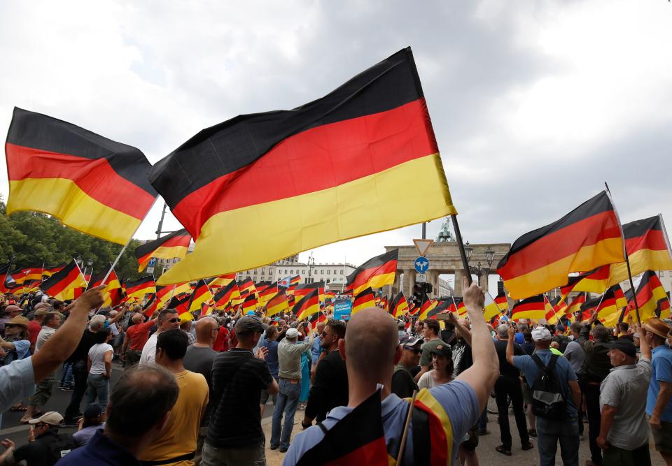 Alternative for Germany (AfD)'s demonstrators wave German flags in front of the Brandenburg Gate (Brandenburger Tor) in Berlin during the "demonstration for the future of Germany" called by the far-right AfD in Berlin on May 27, 2018. Photo: ODD ANDERSEN/AFP/Getty Images