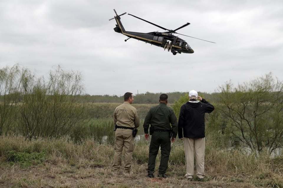President Donald Trump salutes as a U.S. customs and Border Protection helicopter passes as he tours the U.S. border with Mexico at the Rio Grande on the southern border, Thursday, Jan. 10, 2019, in McAllen, Texas. (AP Photo/ Evan Vucci)