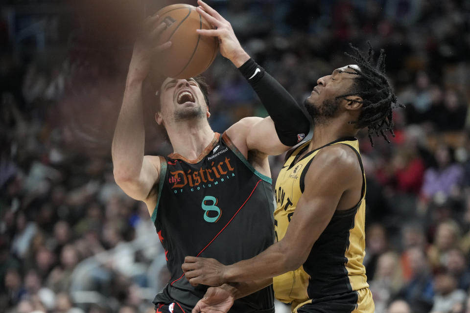 Toronto Raptors guard Immanuel Quickley, right, picks up a foul as he and Washington Wizards forward Deni Avdija (8) make contact during the second half of an NBA basketball game in Toronto on Sunday, April 7, 2024. (Frank Gunn/The Canadian Press via AP)