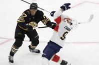 Boston Bruins' Hampus Lindholm (27) commits an interference penalty against Florida Panthers' Oliver Ekman-Larsson during the third period in Game 4 of an NHL hockey Stanley Cup second-round playoff series, Sunday, May 12, 2024, in Boston. (AP Photo/Michael Dwyer)