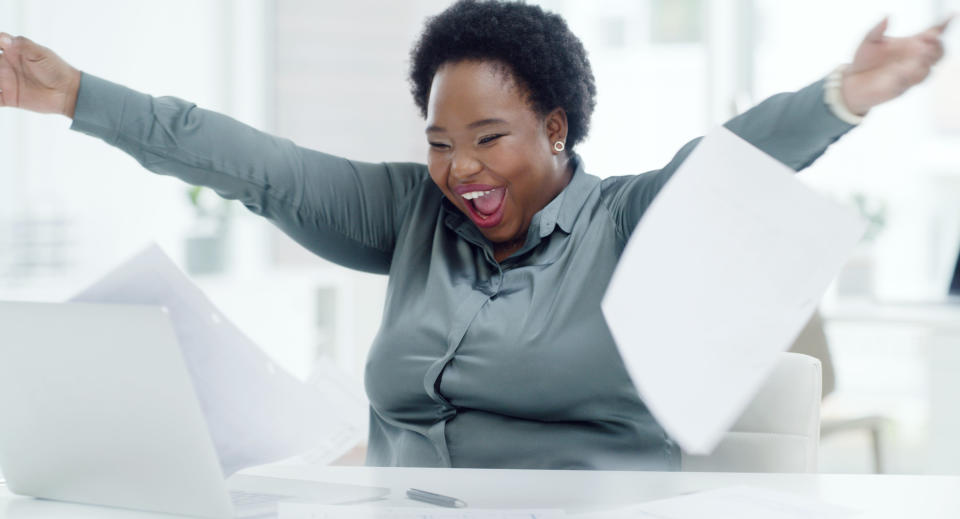 A woman throws papers and smiles gleefully