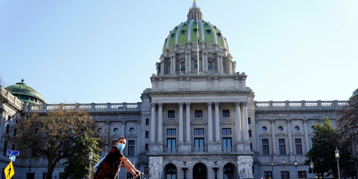 A cyclist rides past the Pennsylvania Capitol in Harrisburg, Pa., on March 22, 2021.