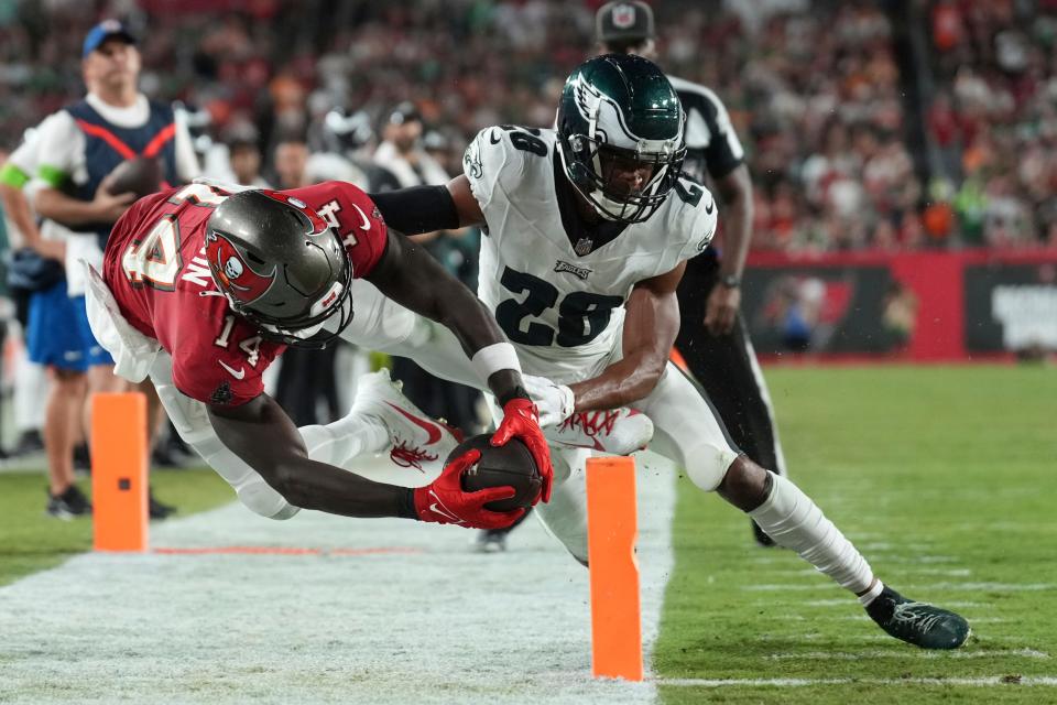 Tampa Bay Buccaneers wide receiver Chris Godwin (14) reaches for the pylon but is forced out by Philadelphia Eagles cornerback Josh Jobe (28) during an NFL football game on Monday, Sept. 25, 2023, in Tampa, Fla.