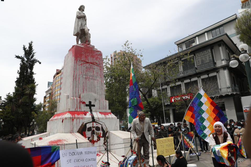 Activists protest Spanish colonization at the Christopher Columbus monument which they painted red to symbolize blood in La Paz, Bolivia, Monday, Oct. 12, 2020, as they mark Decolonization Day, also known as Day of the Race. (AP Photo/Juan Karita)