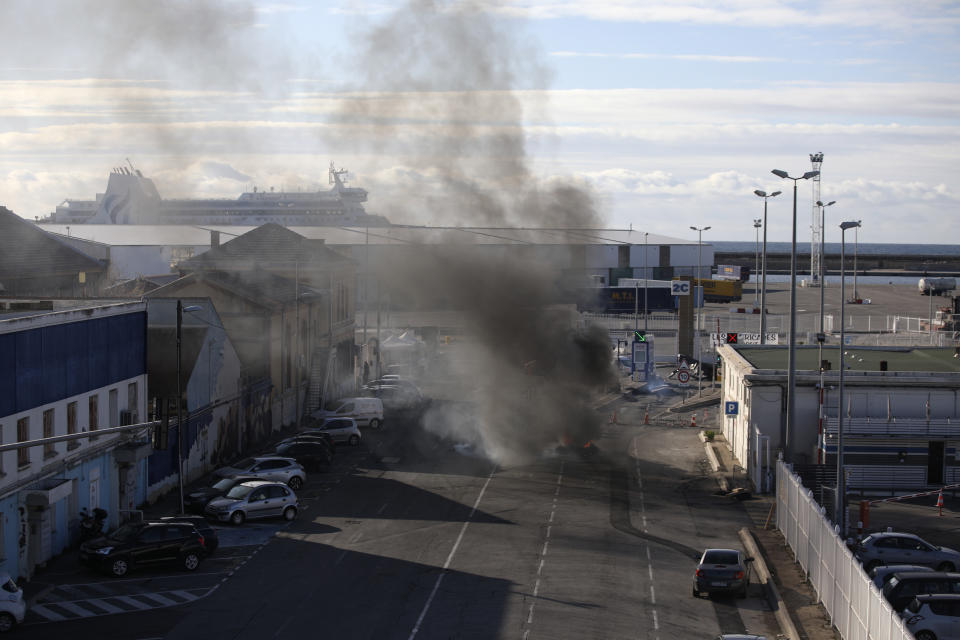 Smokes billows after protesters set vehicles on fire in the Mediterranean port city in Marseille, southern France, Thursday, Dec.12, 2019. Unions have flatly rejected fresh proposals by the government of pro-business President Emmanuel Macron to stagger the roll-out of a plan that would require France's youngest workers - people born after 1974 - to stay on the job until the age of 64 to get full pensions instead of age 62. (AP Photo/Daniel Cole)