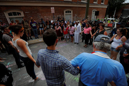 FILE PHOTO: Demonstrators hold hands at the site where Heather Heyer was killed, on the one year anniversary of 2017 Charlottesville "Unite the Right" protests, in Charlottesville, Virginia, U.S., August 12, 2018. REUTERS/Brian Snyder/File Photo