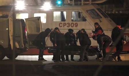 Italian Coast Guard members carry a body as they arrive in the Brindisi harbour December 28, 2014. REUTERS/Ciro De Luca