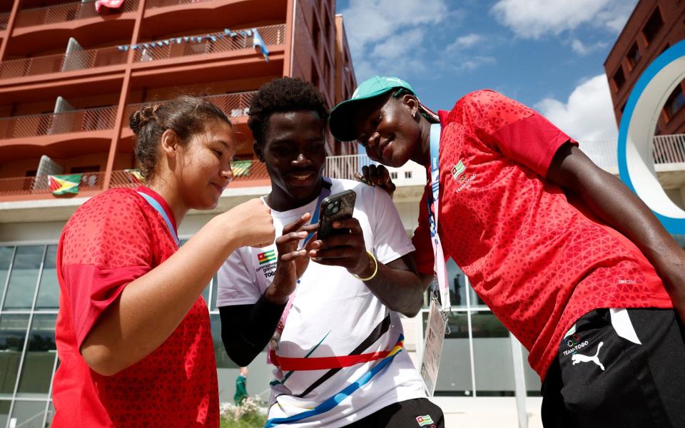 Togo athletes look at photos they have taken in the Olympic village, ahead of Paris 2024, 23 July 2024