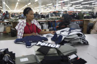 FILE - Laurette Eugene assembles a body armor vest at the Point Blank Body Armor factory in Pompano Beach, Fla., Sept. 19, 2014. When a shooter attacked a supermarket in Buffalo, New York,May 14, 2022, its security guard tried to stop him. At least one of the guard's shots hit the gunman, but it didn’t stop the deadly rampage because the gunman was wearing body armor. (AP Photo/J Pat Carter, File)