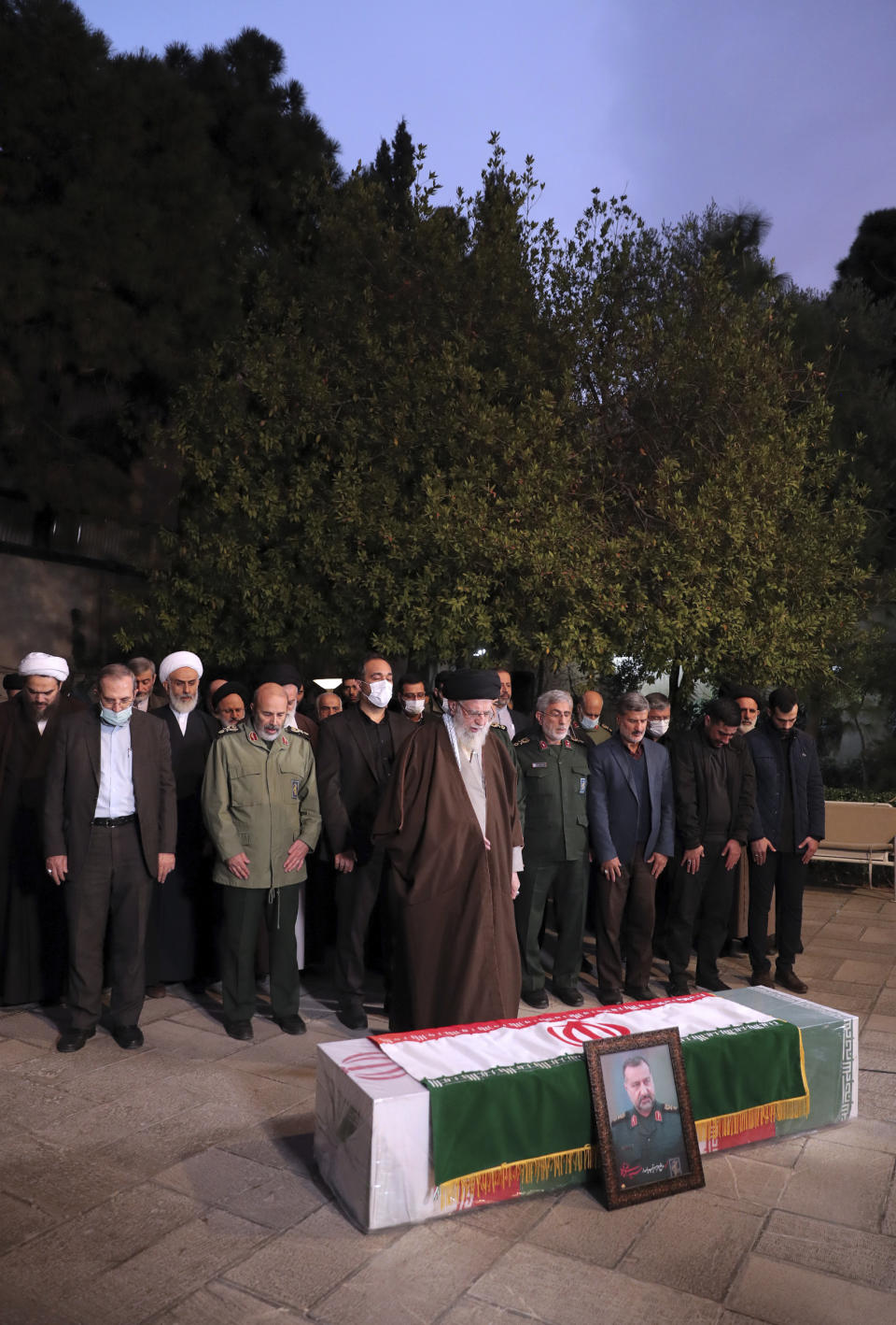 In this photo released by an official website of the office of the Iranian supreme leader, Supreme Leader Ayatollah Ali Khamenei, foreground, prays over the flag-draped coffin of Seyed Razi Mousavi, a high ranking Iranian general of the paramilitary Revolutionary Guard, who was killed in an alleged Israeli airstrike in Syria on Monday, in Tehran, Iran, Thursday, Dec. 28, 2023. (Office of the Iranian Supreme Leader via AP)