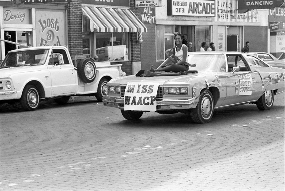 Miss NAACP is seen riding on the hood of a car driving along Main Street in downtown Fort Worth for the Juneteenth parade in 1978.