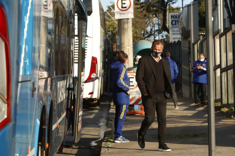 Un integrante de la delegación de Boca baja del uno de los micros en los que se encuentra el plantel