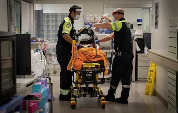 Paramedics transport a patient into the emergency department at Scarborough General Hospital in Toronto earlier this month. (Evan Mitsui/CBC - image credit)