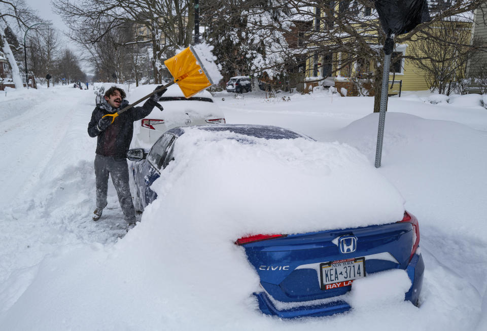 Christian Parker of Buffalo, N.Y., shovels out his car in the Elmwood Village neighborhood of Buffalo, N.Y. Monday, Dec. 26, 2022, after a massive snow storm blanketed the city. Along with drifts and travel bans, many streets were impassible due to abandoned vehicles. (AP Photo/Craig Ruttle)