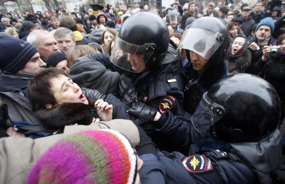 Russian police officers detain opposition activists outside a court room in Moscow, Russia, Monday, Feb. 24, 2014, where hearings started against opposition activists detained on May 6, 2012 during a rally at Bolotnaya Square. A Moscow judge on Friday, Feb. 21, 2014, convicted eight anti-government protesters of rioting during a 2012 protest against Vladimir Putin, following a trial seen as part of the Kremlin's efforts to stifle dissent. (AP Photo/Denis Tyrin)