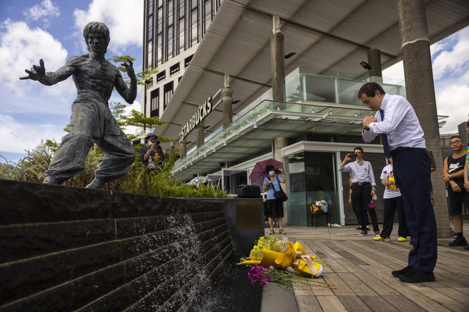 Fans gather in front of the statue of martial artist Bruce Lee to commemorate the 50th anniversary of his death in Hong Kong, Thursday, July 20, 2023. (AP Photo/Louise Delmotte)