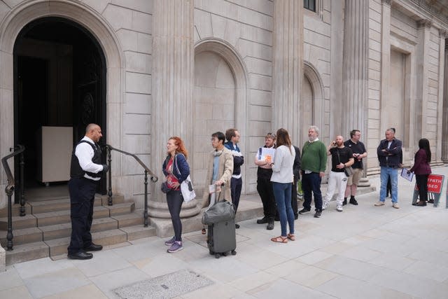 People queue outside the Bank of England, London, on the day the new banknotes featuring the King’s portrait are being issued