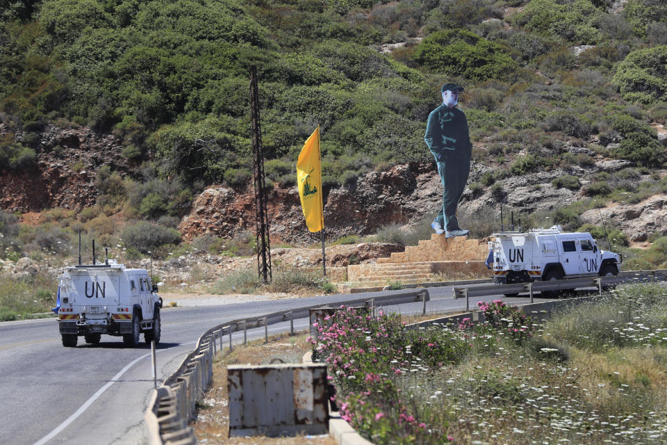 CORRECTS TO SAY CALLED TO RESUME INDIRECT TALKS NOT RESUMED TALKS - U.N. peacekeeping vehicles pass a Hezbollah flag and a statue of the late Iranian General Qassem Soleimani, as they patrol on a road along the Lebanese-Israeli border town of Naqoura, while Lebanon and Israel are being called to resume indirect talks over their disputed maritime border with U.S. mediation, south Lebanon, Monday, June 6, 2022. The Lebanese government invited on Monday a U.S. envoy mediating between Lebanon and Israel over their disputed maritime border to return to Beirut as soon as possible to work out an agreement amid rising tensions along the border. (AP Photo/Mohammed Zaatari)