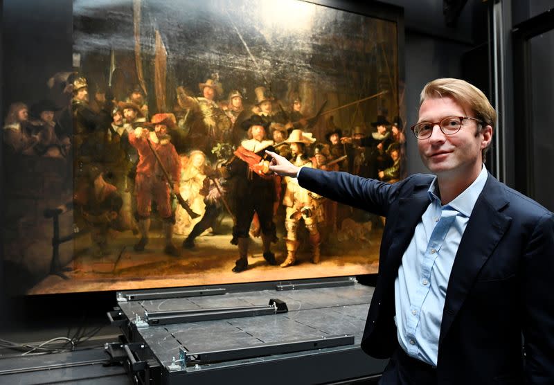 Museum director Taco Dibbits points to Rembrandt's famed Night Watch at Rijksmuseum in Amsterdam