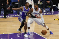 Los Angeles Clippers guard Paul George, right, drives to the basket against Sacramento Kings guard De'Aaron Fox during the first quarter of an NBA basketball game in Sacramento, Calif., Friday, Jan. 15, 2021. (AP Photo/Rich Pedroncelli)