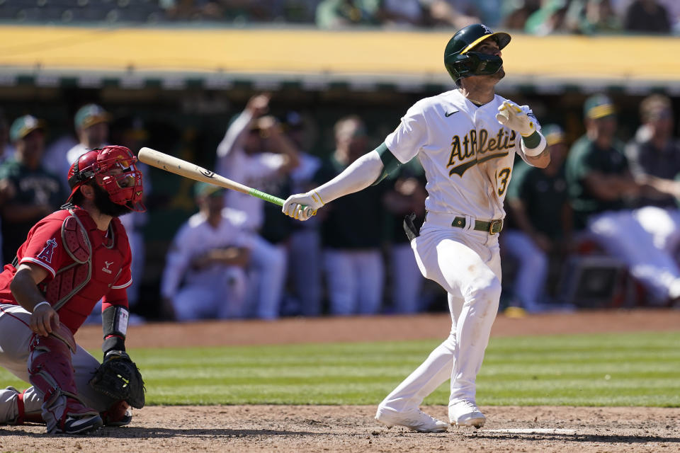 Oakland Athletics' Luis Barrera, right, watches his three-run home run in front of Los Angeles Angels catcher Austin Romine during the ninth inning of the first baseball game of a doubleheader in Oakland, Calif., Saturday, May 14, 2022. (AP Photo/Jeff Chiu)