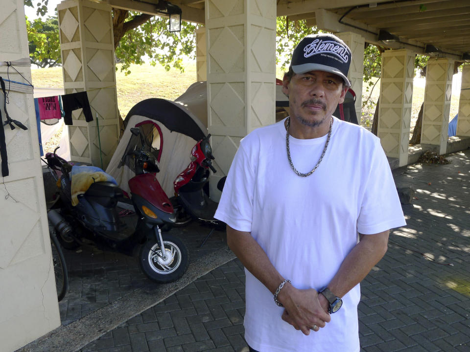 A homeless man who identified himself as "Mike" poses for a photo in front of the encampment where he lives on Wednesday, Feb. 8, 2017, in Honolulu, Hawaii. Hawaii lawmakers are exploring setting up "safe zones" for homeless people to camp in an effort to reduce the number of people living on the streets. (AP Photo/Cathy Bussewitz)