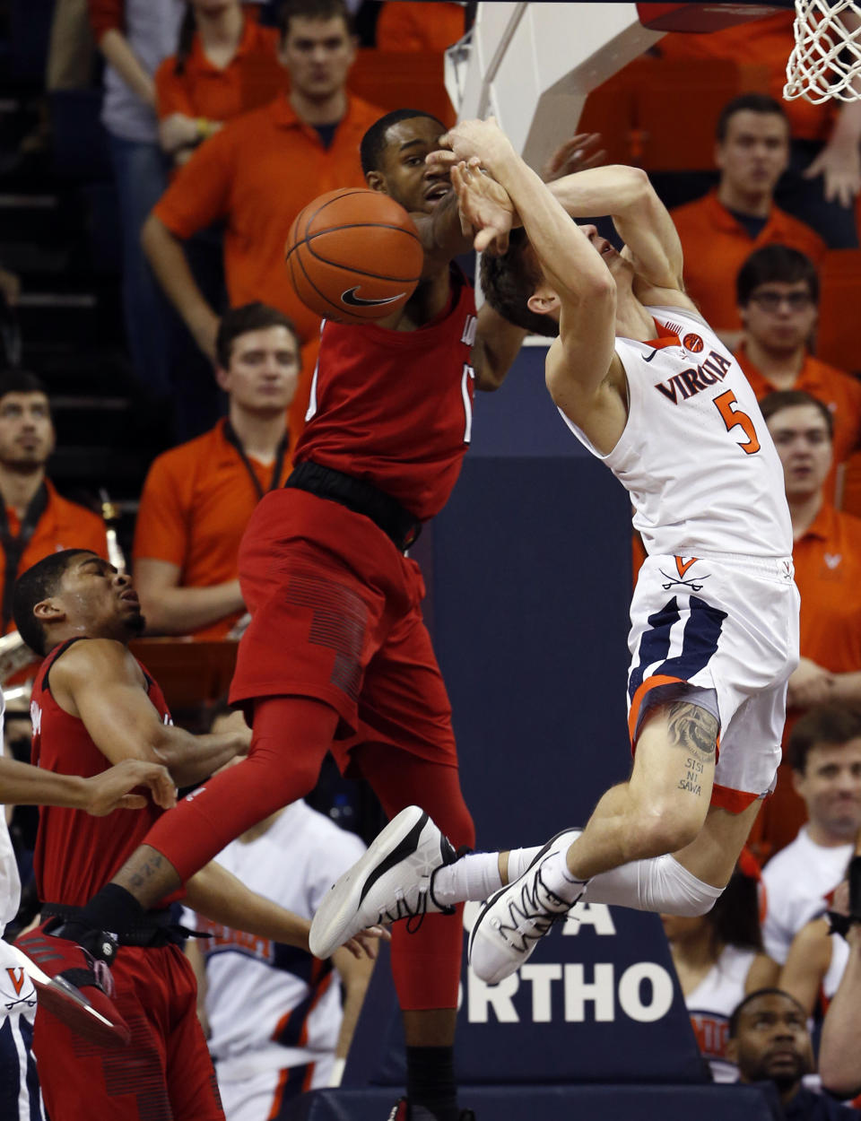 Louisville guard Christen Cunningham (1) strips the ball from Virginia guard Kyle Guy (5) during the first half of an NCAA college basketball game in Charlottesville, Va., Saturday, March 9, 2019. (AP Photo/Steve Helber)