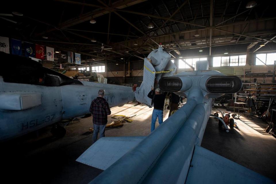 Work takes place on a Bell AH-1W Cobra attack helicopter, right, and a SH-60B Seahawk helicopter, left, inside Castle Air Museum’s restoration hanger in Atwater, Calif., on Wednesday, Jan. 12, 2022. According to Castle Air Museum Chief Executive Director Joe Pruzzo, both helicopters were acquired from Hawaii in 2021. When ready, the aircraft will be displayed on the Castle Air Museum grounds along with dozens of other vintage aircraft.