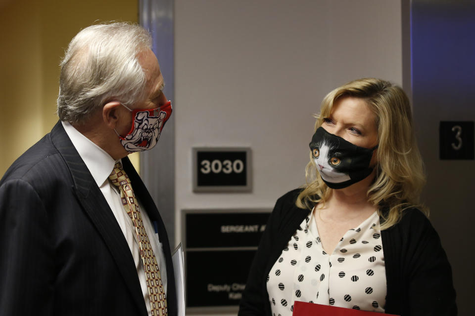 State Sen. Jim Nielsen, R-Gerber, left, wears a face mask representing his alma mater, the Bulldogs of Fresno State, as he talks with cat-fancier Sen. Cathleen Galgiani, D-Stockton, after the Senate session in Sacramento, Calif., Thursday, July 2, 2020. State lawmakers and those entering the Capitol are required to wear face masks and people often comply with their own personal tastes. (AP Photo/Rich Pedroncelli)