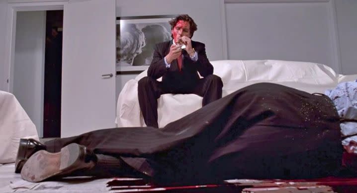 Patrick Bateman stares at a dead victim in American Psycho