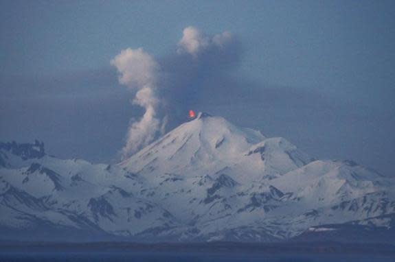 A lava fountain at the top of Alaska's Pavlof volcano, seen from Cold Bay on May 14, 2013. Steam and ash rise from the northwest slope as lava flows downward.