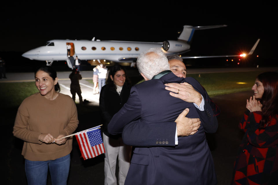 Family members embrace freed Americans Siamak Namazi, Morad Tahbaz and Emad Shargi, as well as two returnees whose names have not yet been released by the U.S. government, who were released in a prisoner swap deal between U.S and Iran, as they arrive at Davison Army Airfield, Tuesday, Sept. 19, 2923 at Fort Belvoir, Va. (Jonathan Ernst/Pool via AP)