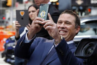 Papa John's President & CEO Rob Lynch photographs with his mobile phone outside the Nasdaq MarketSite, after ringing the opening bell, in New York, Tuesday, Oct. 1, 2019. (AP Photo/Richard Drew)