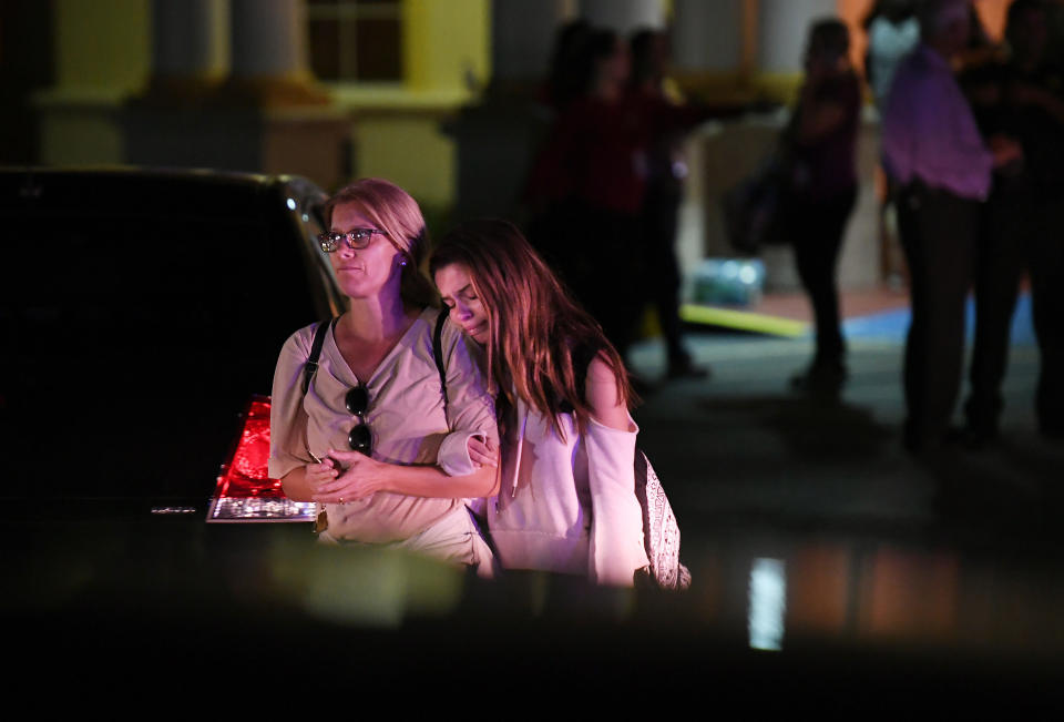 People embrace while leaving the Fort Lauderdale Marriott Coral Springs Hotel after a deadly shooting at Marjory Soneman Douglas High School.