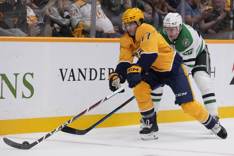 Nashville Predators right wing Luke Evangelista (77) skates the puck past Dallas Stars defenseman Esa Lindell (23) during the second period of an NHL hockey game Thursday, Oct. 10, 2024, in Nashville, Tenn. (AP Photo/George Walker IV)