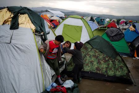 Migrant children, who are waiting to cross the Greek-Macedonian border, play outside their tent at a makeshift camp near the village of Idomeni, Greece March 9, 2016. REUTERS/Stoyan Nenov