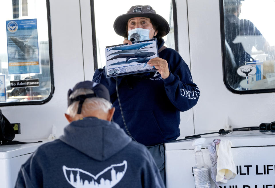 Naturalist Celia Ackerman speaks to those who have joined a whale watching cruise aboard the American Princess Wednesday, Sept. 23, 2020, off the New York coastline. Whale watch captains and scientists around America's most populous city say recent years have seen a tremendous surge in the number of whales observed in the waters around the Big Apple. (AP Photo/Craig Ruttle)