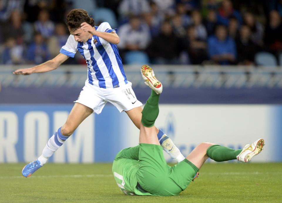 Real Sociedad's Ruben Pardo (L) jumps over Shakhtar Donetsk's goalkeeper Andriy Pyatov during their Champions League group A soccer match at Anoeta stadium in San Sebastian, northern Spain, September 17, 2013. REUTERS/Vincent West (SPAIN - Tags: SPORT SOCCER)